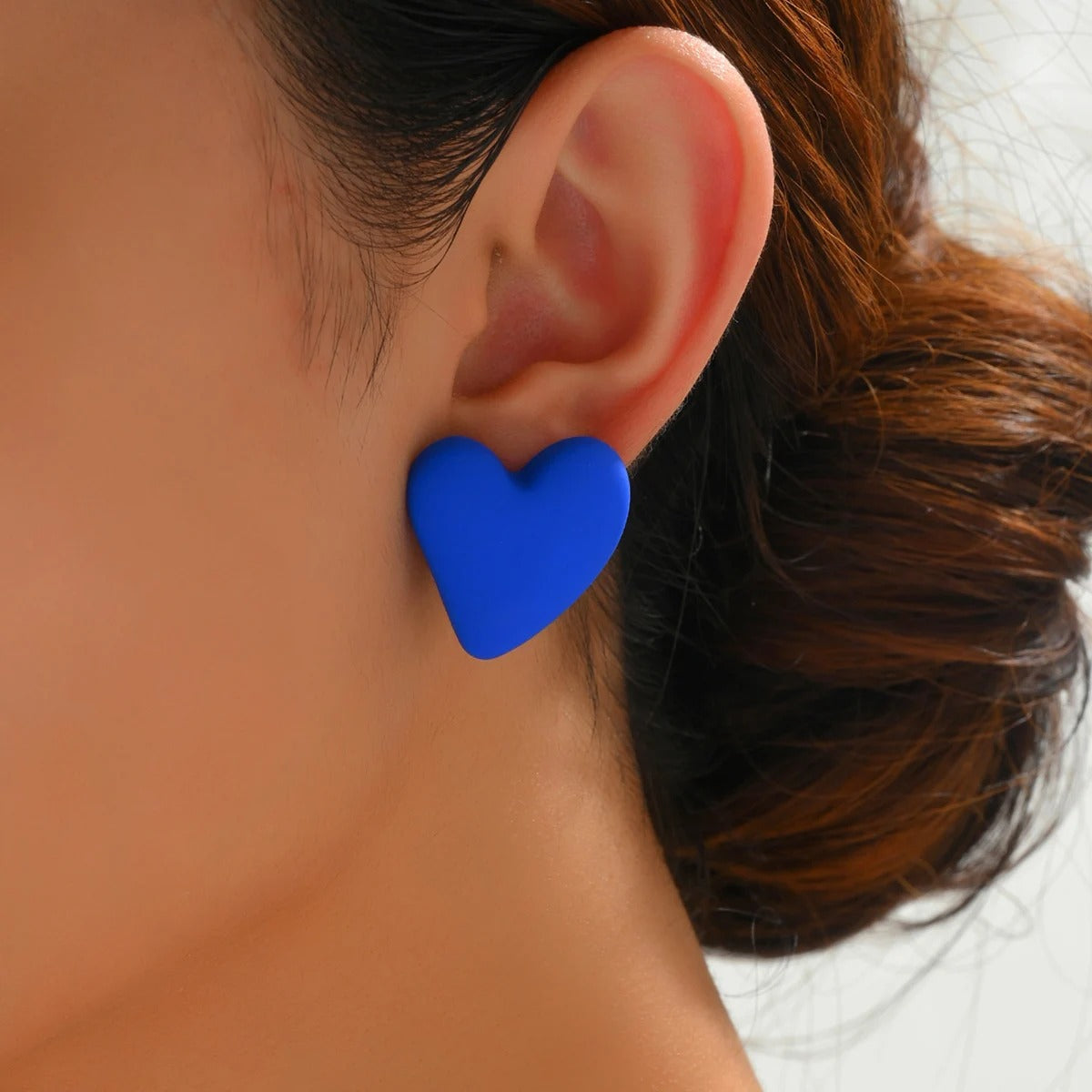 Boucle D'oreille Femme Cœur Lisse Bleu portée par une femme de profil on ne voit que son oreille