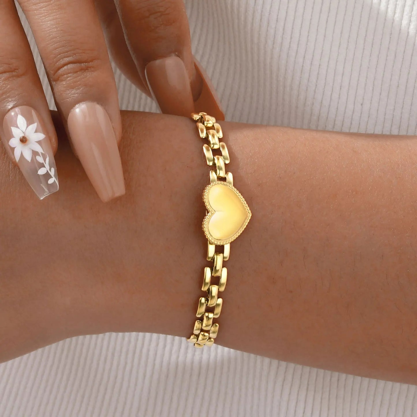 Bracelet Femme Chaîne Dorée Cœur Satiné porté au poignet d'une femme