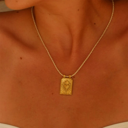 Collier Femme Pendentif Carte Tarot Cœur doré sur corde jaune autour du coup d'une femme.