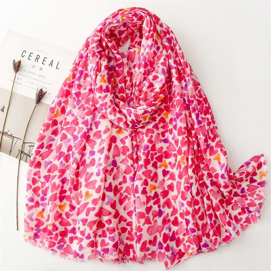 Foulard Femme Cœurs Envoûtants présenté sur fond blanc avec un magazine et des fleurs séchées