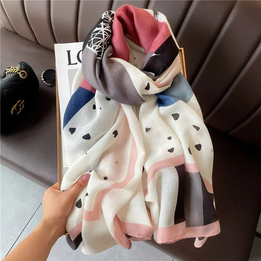 Foulard Femme Cœurs Et Graphiques présenté sur une boite sur un canapé cuir marron