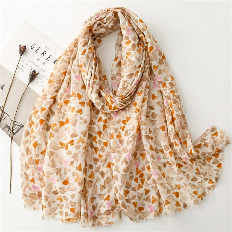Foulard Femme Nuances De Cœurs présenté sur un fond blanc avec un magazine te 2 fleurs séchées