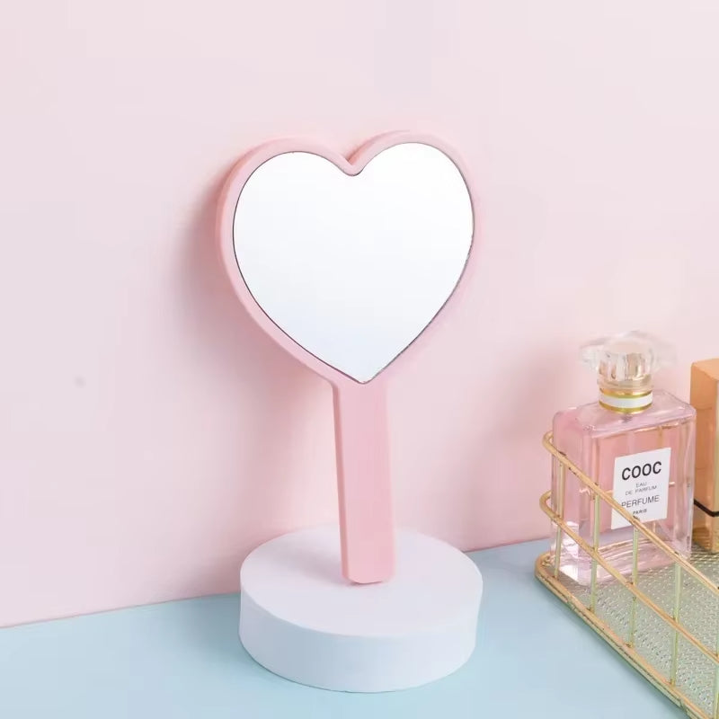 Miroir de Poche en Forme de Coeur sur un meuble avec un parfum à droite
