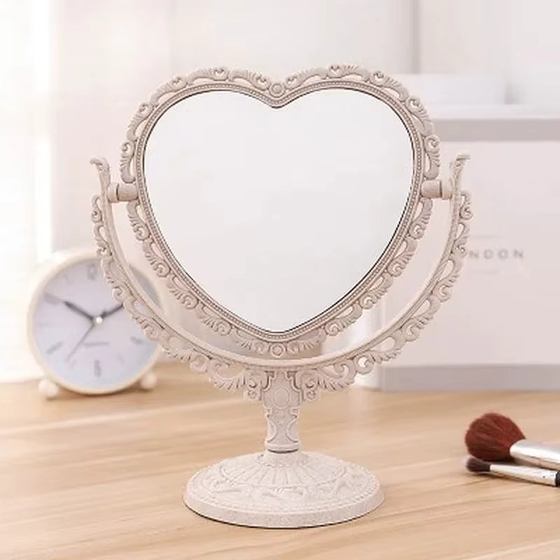Miroir à Poser Vintage Coeur sur un meuble avec un réveil en fond et des pinceaux à droite