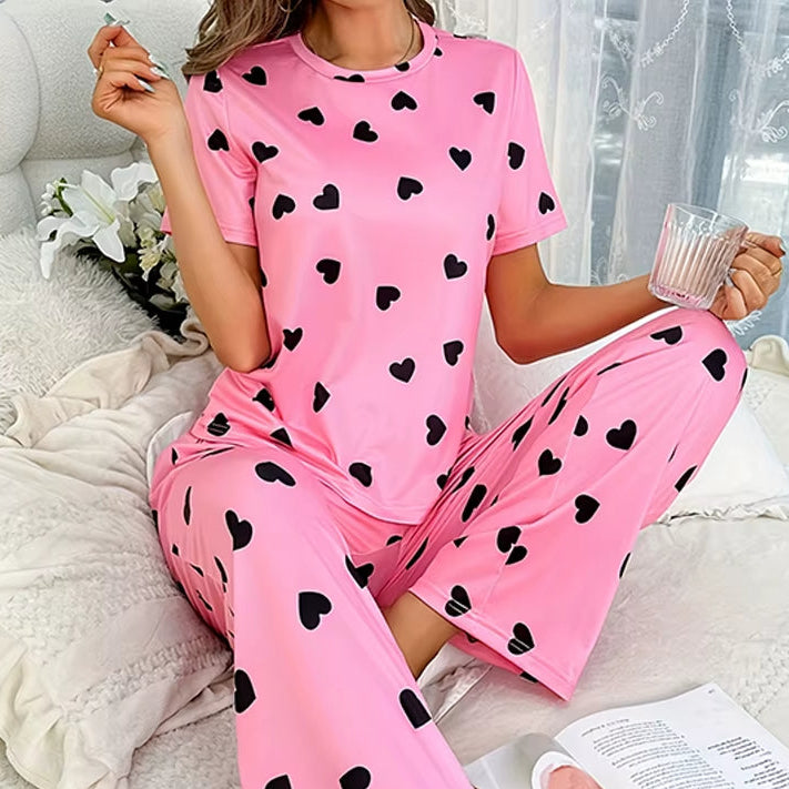 Pyjama Femme Rose à Coeurs sur une femme sur un lit