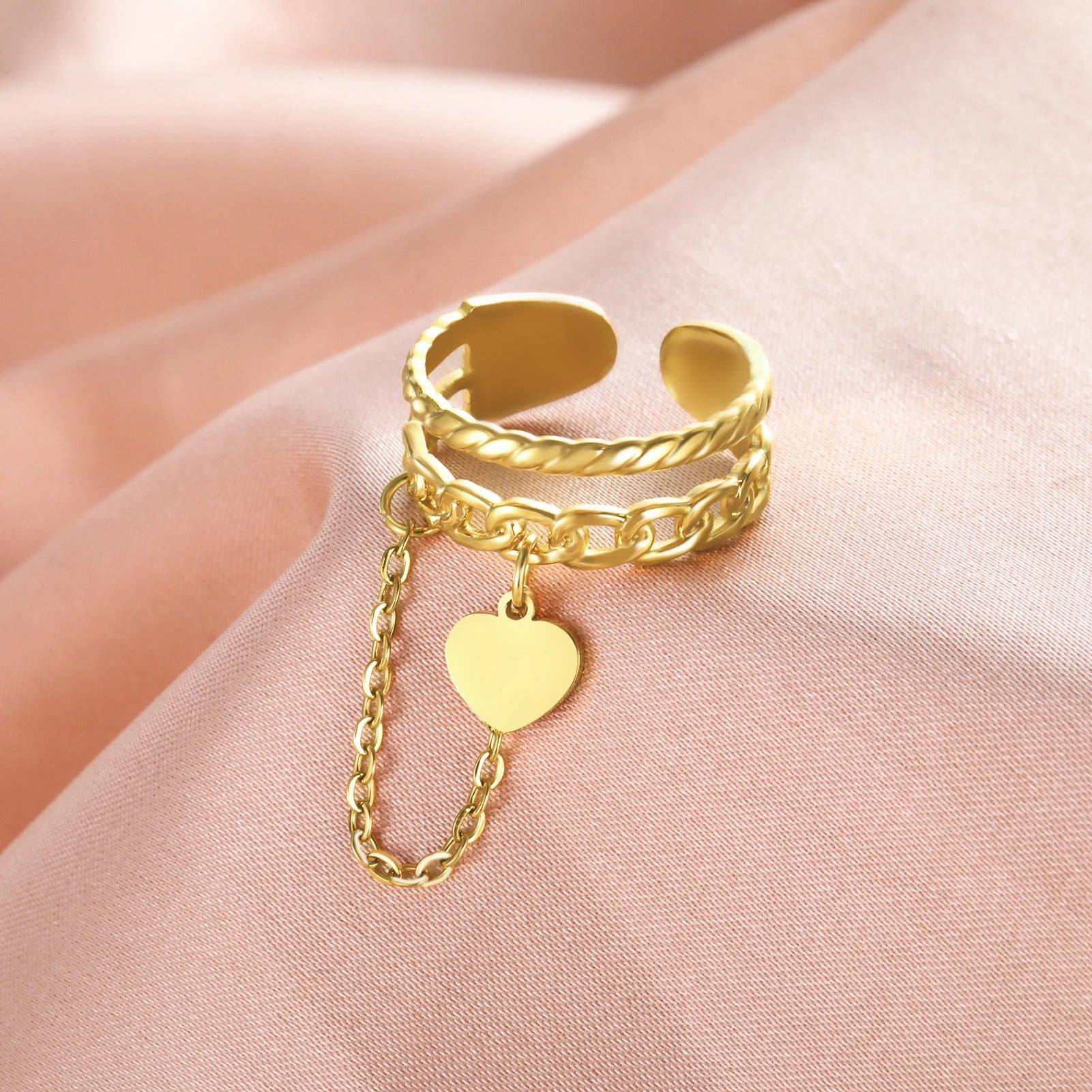 Bague Femme Ajustable Chaine et Cœur présenté sur un tissu satin rose