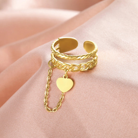 Bague Femme Ajustable Chaine et Cœur présenté sur un tissu satin rose