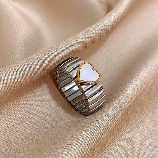 Bague Femme Élastique Cœur Nacré argenté présenté sur un tissu beige satiné