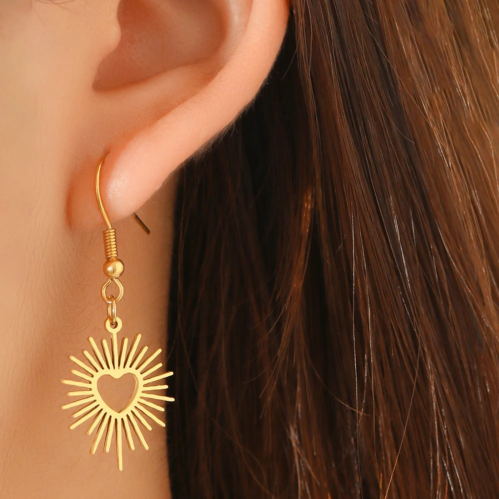 Boucle D'oreille Femme cœurs ensoleillés dorées  portées par une femme de profil