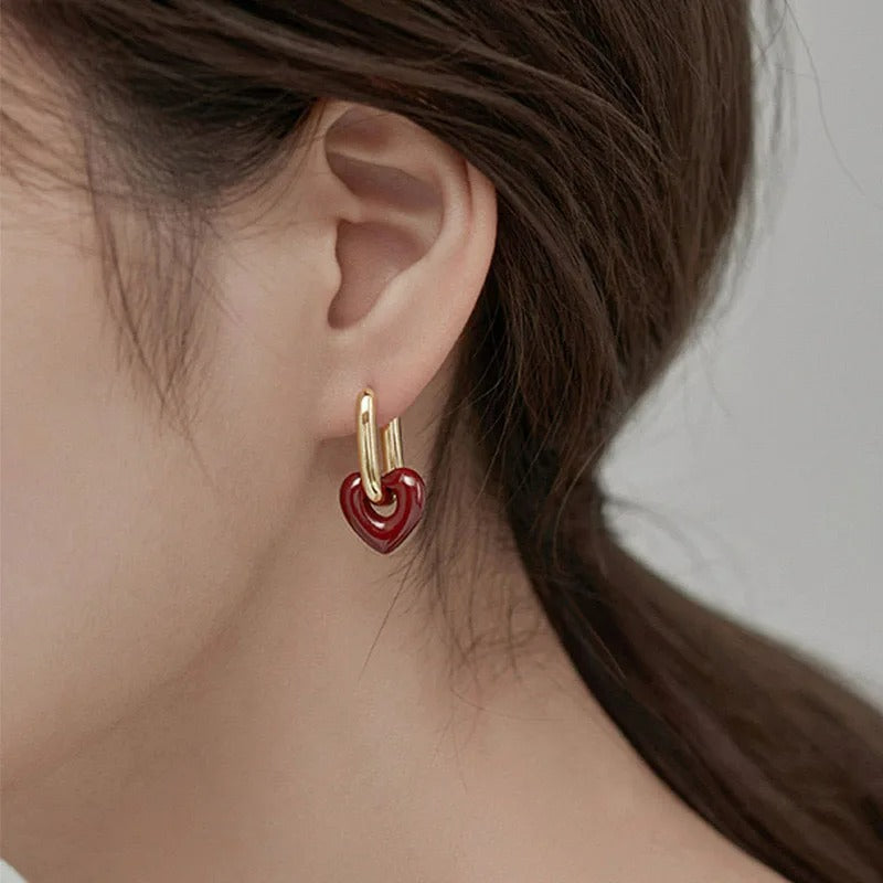Boucle D'oreille Femme Dorée Cœur Rouge, portée par une mannequin de profil