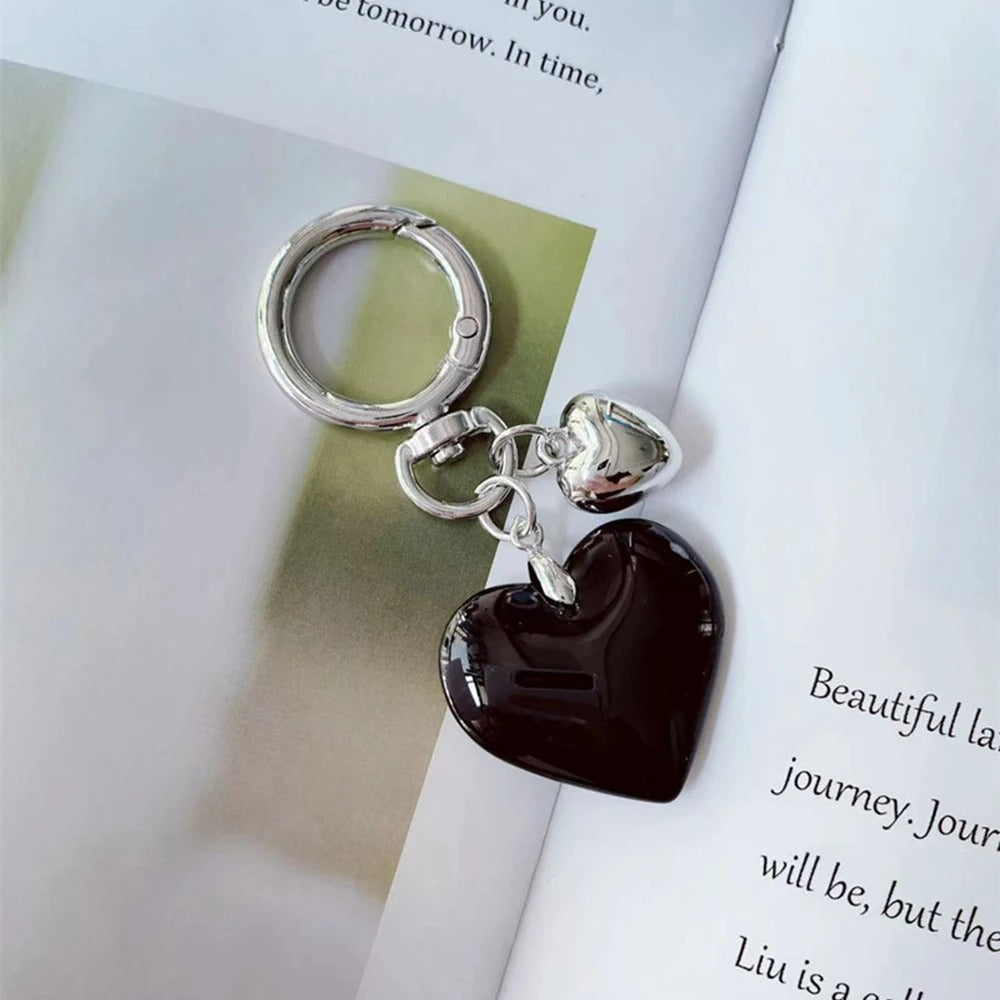 Porte Clé Cœurs Noir et Argenté présenté sur un magazine